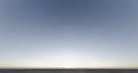 a lone white van on an open plain with blue skies and low visibility with the sun in the background