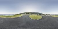 a panoramic photo shows the road and grassy land that has just gone under construction