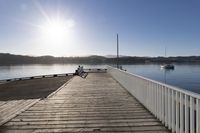 the sun is shining over the bay and a dock on the water's edge