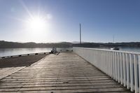 the sun is shining over the bay and a dock on the water's edge