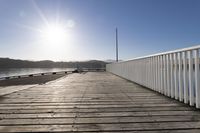 the sun is shining over the bay and a dock on the water's edge