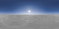 a very large expanse with a sun in the sky above it near some tracks and cars