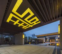 the entrance of a building that is lit up at night with yellow lights on it