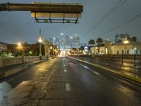 an empty road with traffic on both sides during night time with the city light glowing on the building