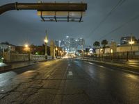 an empty road with traffic on both sides during night time with the city light glowing on the building