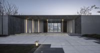 a courtyard with concrete floors, lanterns and plants near the entrance to a modern house