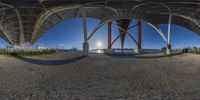 there is a fish eye view of some sort of structure in this picture that's in the sand