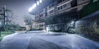 a parking lot is lit up with some lights and planters and trees around it