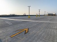 a parking lot is filled with lots of markings on concrete slabs and poles, which give direction to go