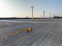 a parking lot is filled with lots of markings on concrete slabs and poles, which give direction to go