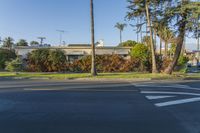 the intersection has a two way sign pointing the way to a house and trees on the other side of the road