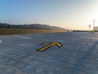 a yellow arrow marks a parking area outside of a building with a mountain behind it