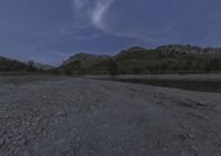 the night time view shows the low water levels on a riverbed with trees on both sides