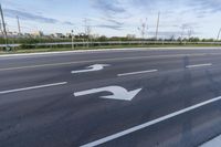 this is an image of a road that has two arrows painted on it that point in the directions