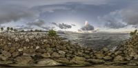 a body of water with rocks in it near the ocean and a bridge over the ocean