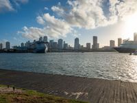 the view of a city in the sun with some palm trees next to the boardwalk