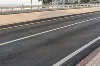 two lanes with a red stop sign beside it on an empty road while people ride bikes