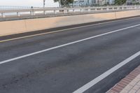 two lanes with a red stop sign beside it on an empty road while people ride bikes