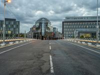 a person on an empty street with tall buildings around them and a city in the background