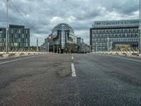 a person on an empty street with tall buildings around them and a city in the background