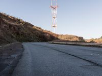 there is a small radio tower on the side of a mountain road near a curve