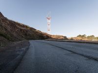 there is a small radio tower on the side of a mountain road near a curve