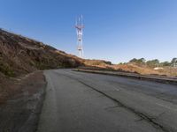 there is a small radio tower on the side of a mountain road near a curve