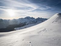 the sun is shining on a mountain peak as the snowboarders make their way down