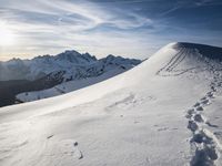 the sun is shining on a mountain peak as the snowboarders make their way down