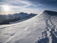 the sun is shining on a mountain peak as the snowboarders make their way down