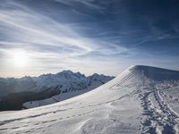 the sun is shining on a mountain peak as the snowboarders make their way down