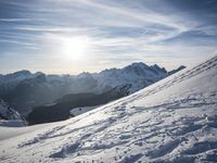 the sun is shining on a mountain peak as the snowboarders make their way down