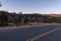 Dawn on Rural Road: Mountain Landscape and Clear Sky