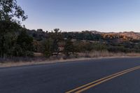 Dawn on Rural Road: Mountain Landscape and Clear Sky