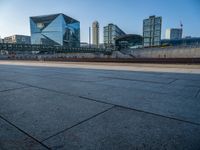 a skateboarder riding on a cement ramp next to a city street under a bridge