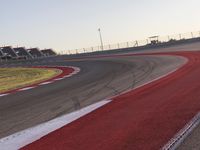 an empty race track with several buildings near by with a red and white border,