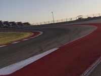 an empty race track with several buildings near by with a red and white border,