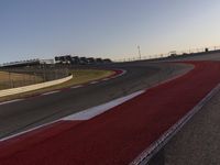 an empty race track with several buildings near by with a red and white border,