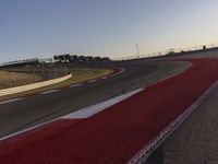 an empty race track with several buildings near by with a red and white border,