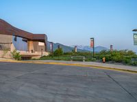 a building that has a bunch of windows on it at sunset with mountains in the background