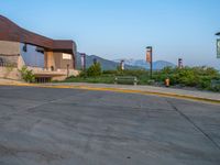 a building that has a bunch of windows on it at sunset with mountains in the background