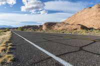 there is a motorcycle parked by the side of the road in the desert, under the mountains