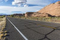 there is a motorcycle parked by the side of the road in the desert, under the mountains