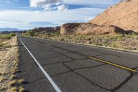 there is a motorcycle parked by the side of the road in the desert, under the mountains