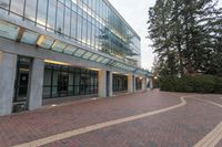 an open space with many windows has many bushes and trees at the outside of the building