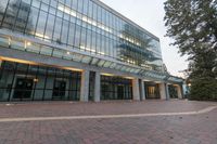 an open space with many windows has many bushes and trees at the outside of the building