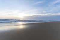 the ocean is blue and still calm as we walk along this beach, at dusk