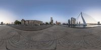 a fish eye lens has taken a photo of a view of buildings and water with a large bridge