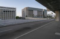 the empty city highway has a bunch of cars driving down it and buildings on both sides