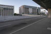 the empty city highway has a bunch of cars driving down it and buildings on both sides